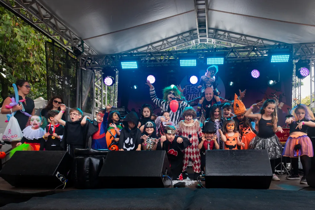 Crianças fantasiadas no palco com o mágico e o Beetlejuice